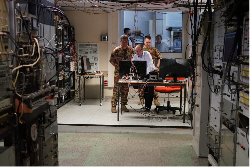 Tre persone osservano lo schermo di un computer nella sala di controllo della Croce del Nord